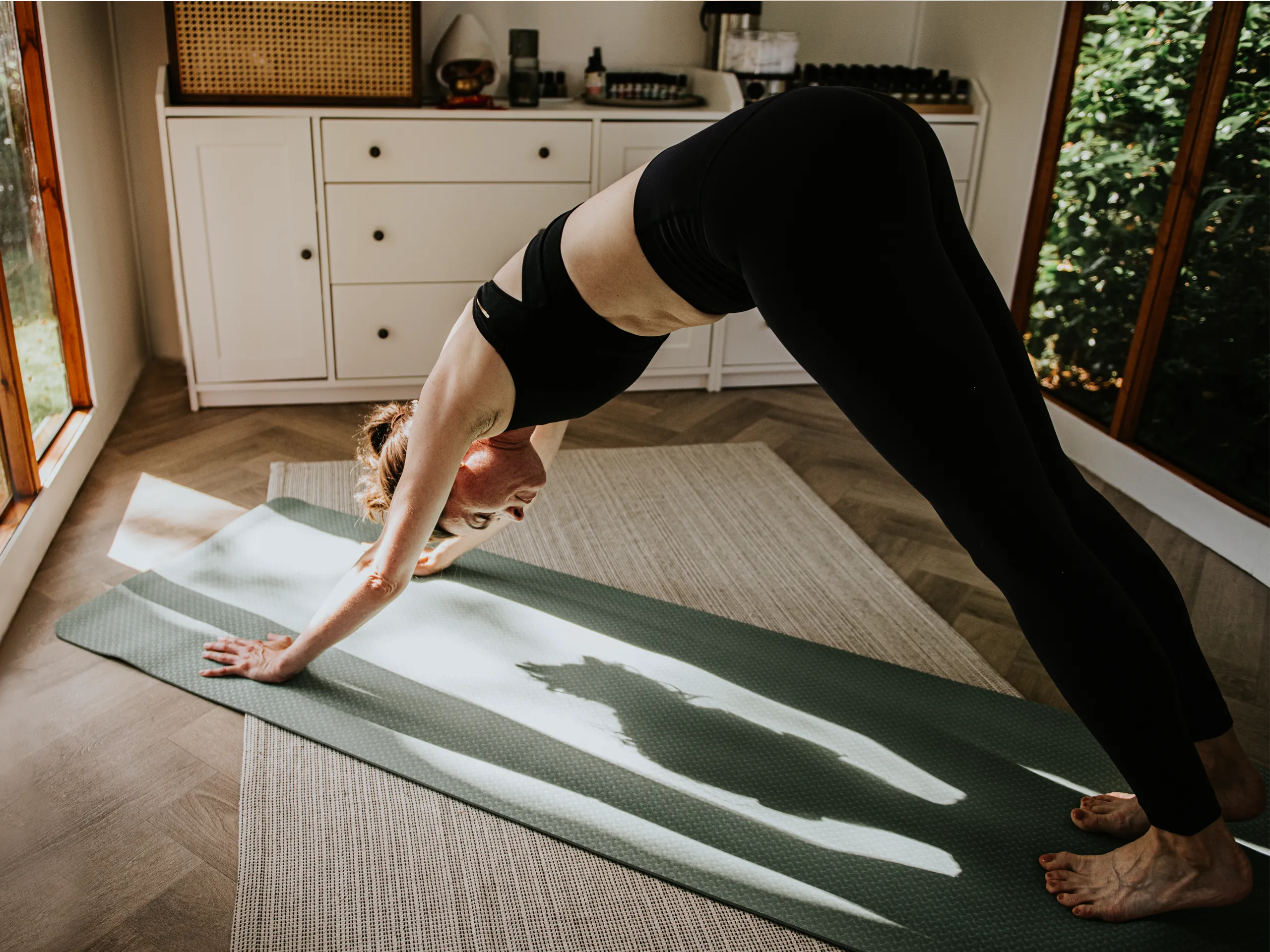 Frau macht Yoga auf einer Matte in einem hellen Raum