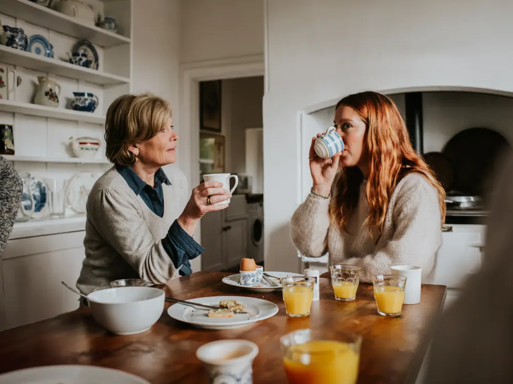 Zwei Frauen trinken Kaffee beim Frühstück in einer gemütlichen Küche