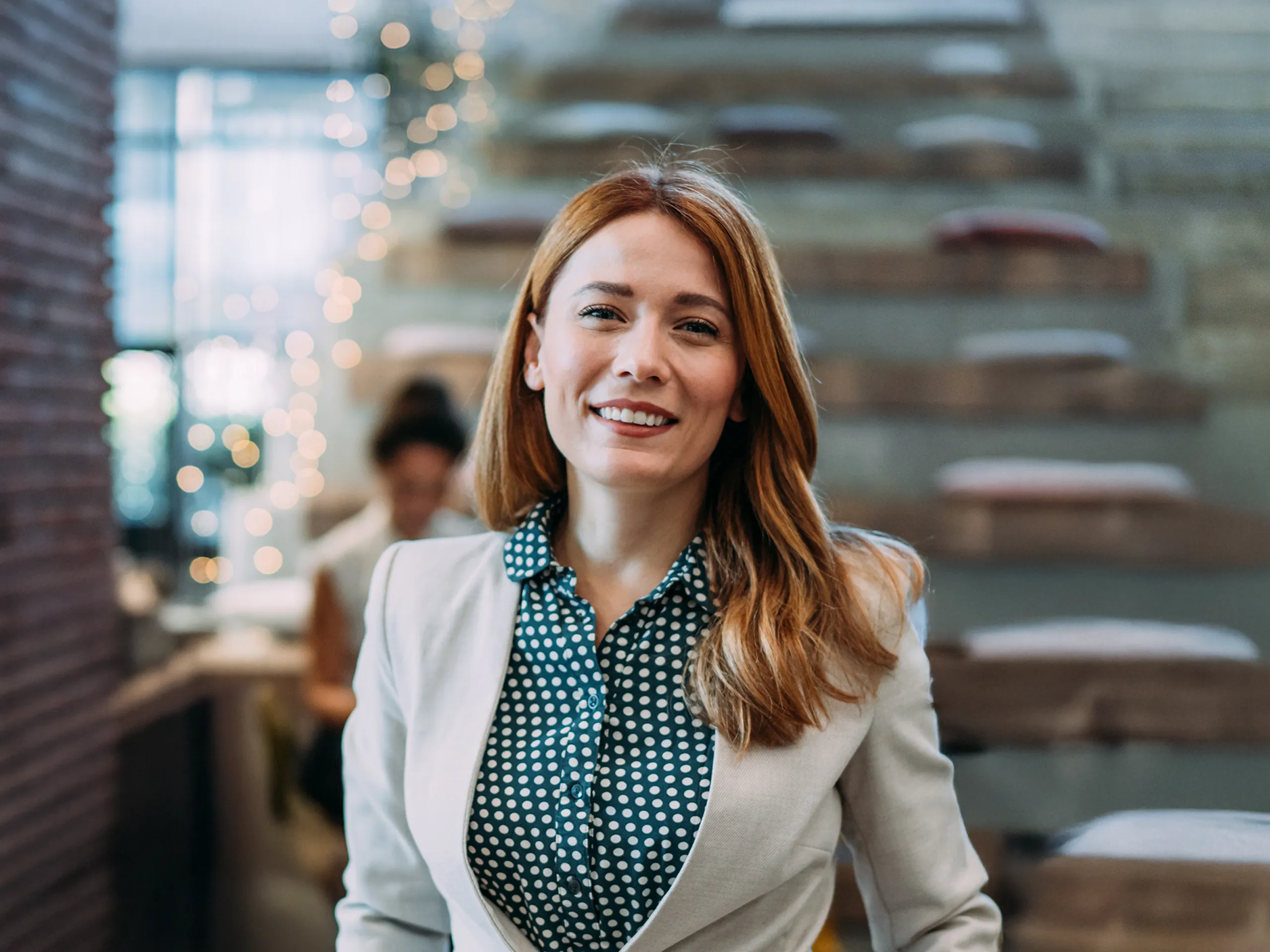 Lächelnde Frau im Business-Outfit in modernem Büro