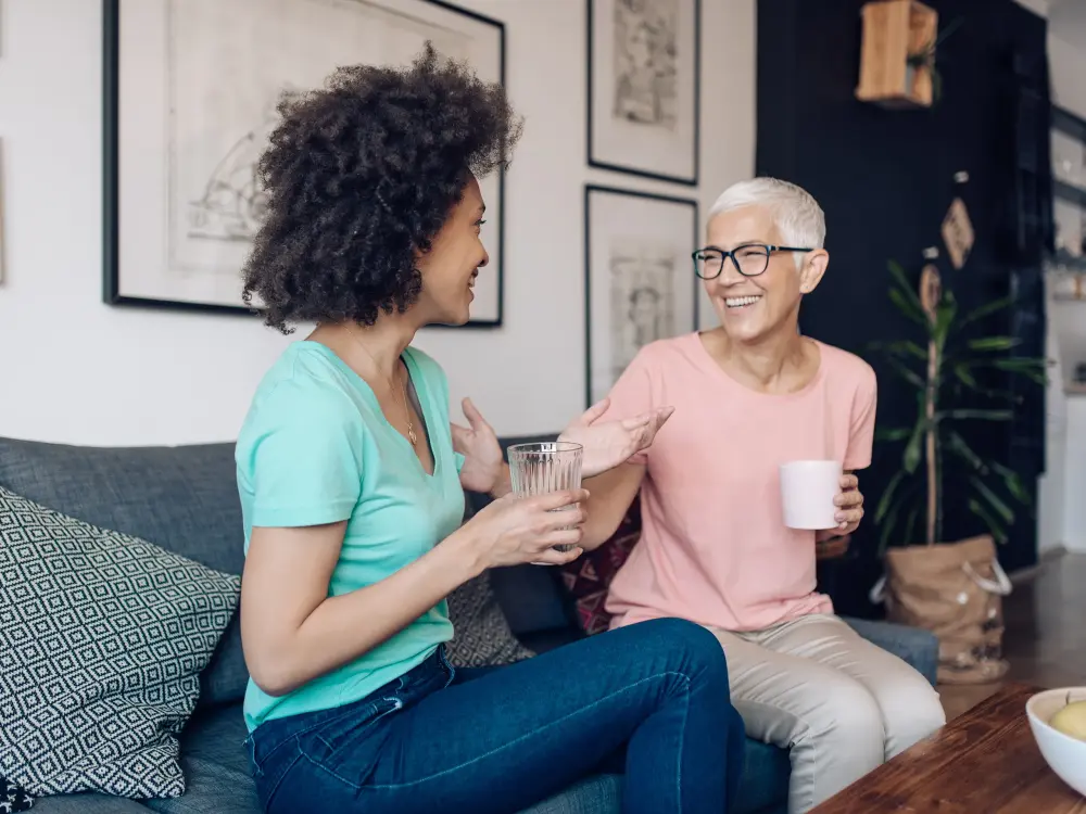 Zwei Frauen unterhalten sich freundlich auf einer Couch