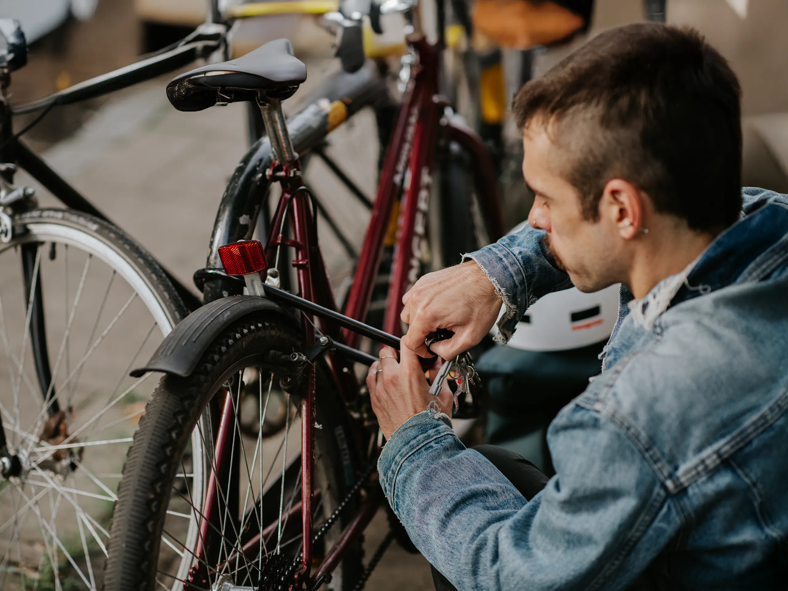 Mann schließt Fahrrad an Fahrradständer ab.