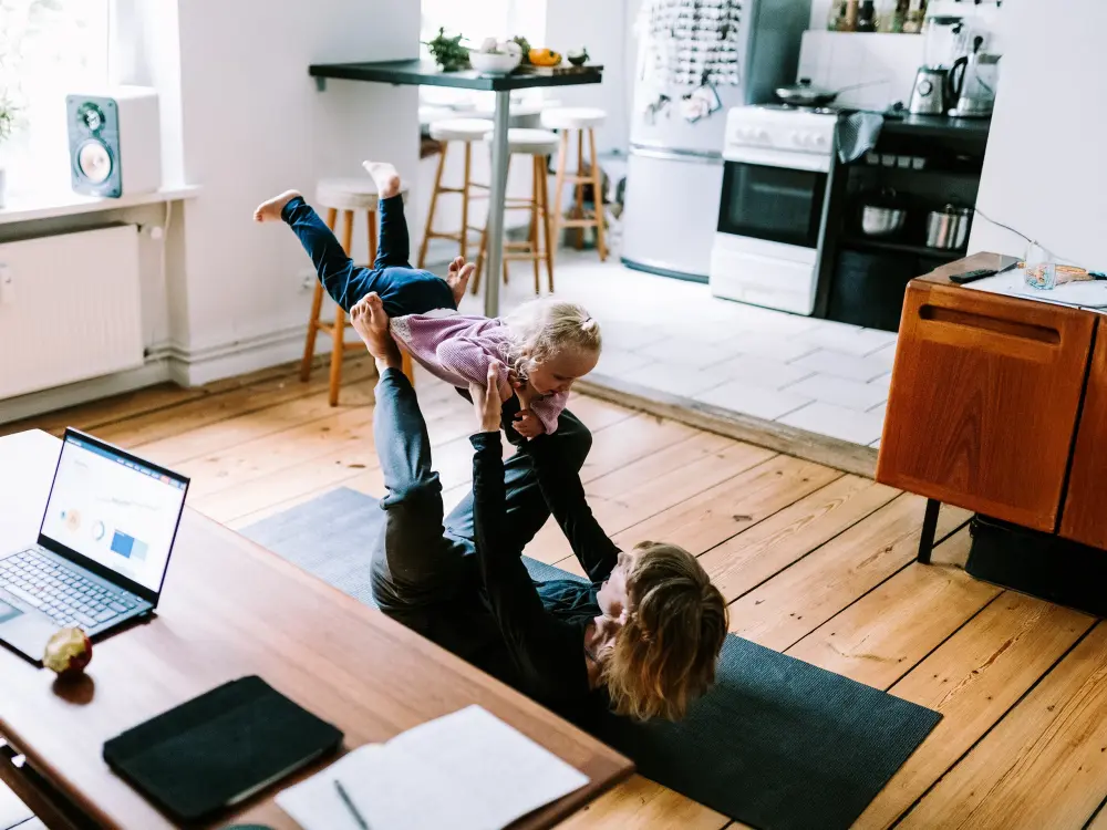 Mutter spielt auf einer Yogamatte mit ihrem Kind in der Wohnung