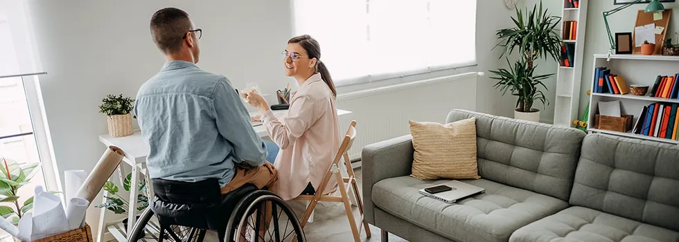 Mann im Rollstuhl spricht mit Frau