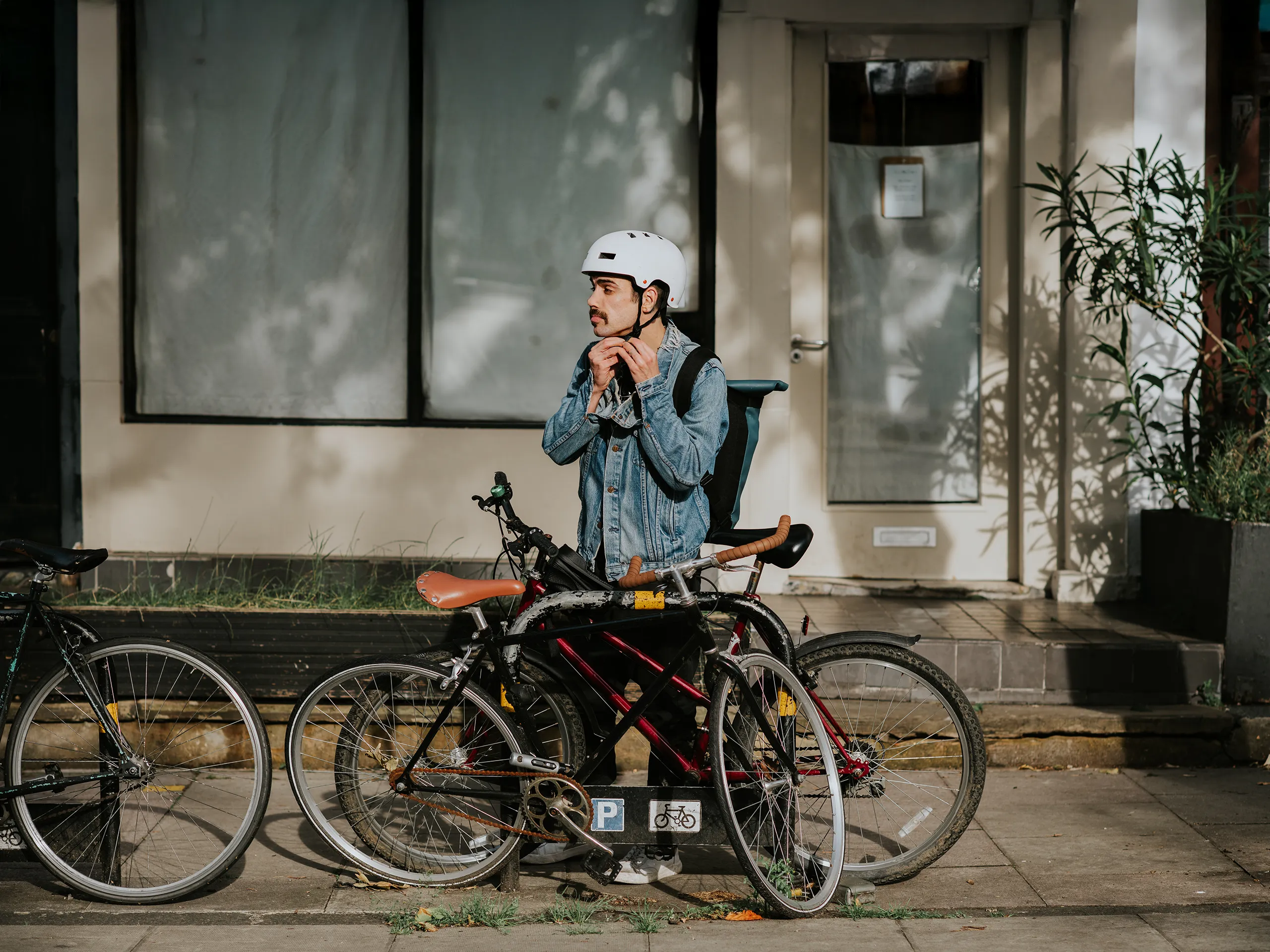 Radfahrer mit Helm schließt sein Fahrrad ab.